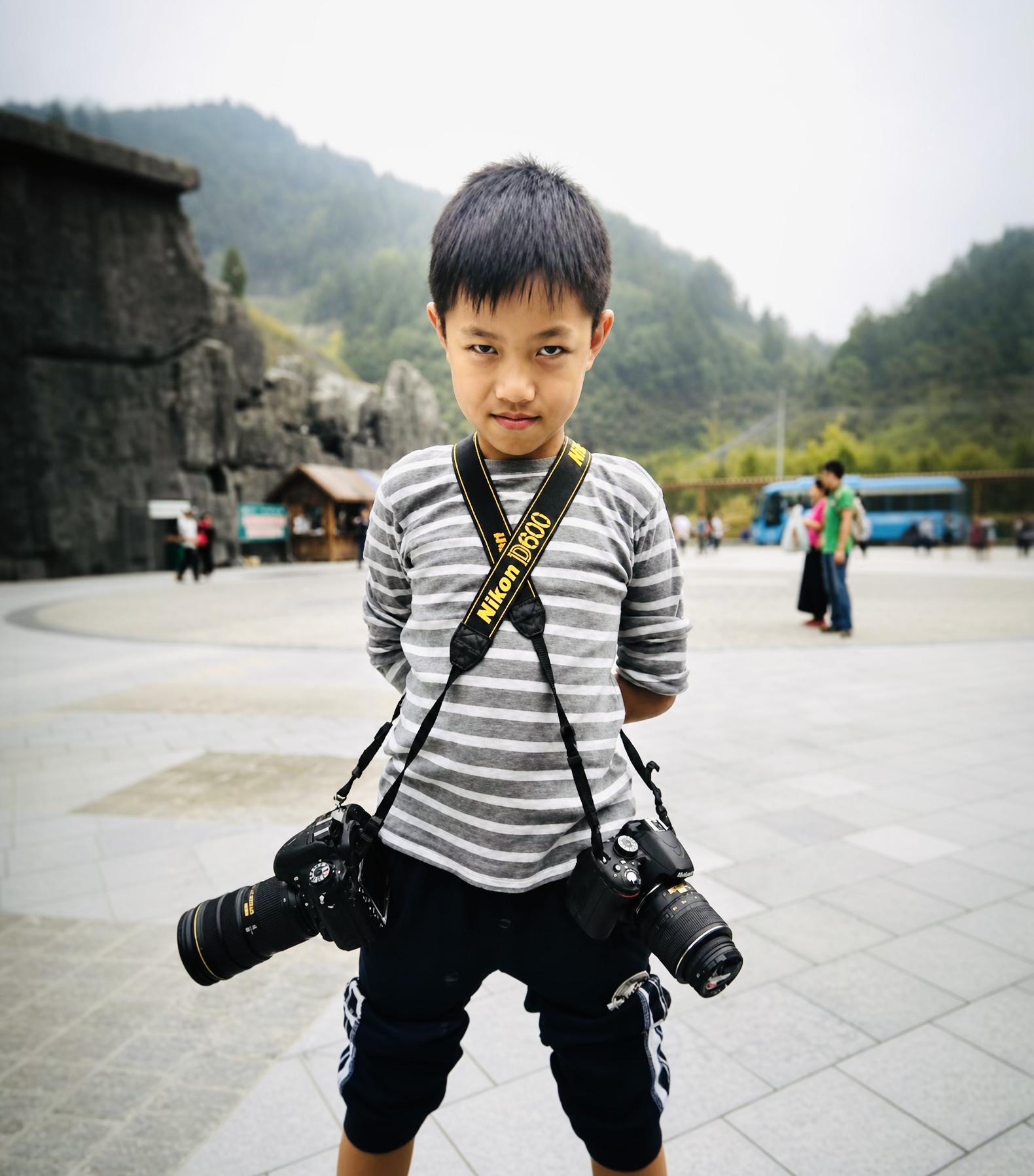 Harry Liu as a child wearing a harness with two Nikon cameras